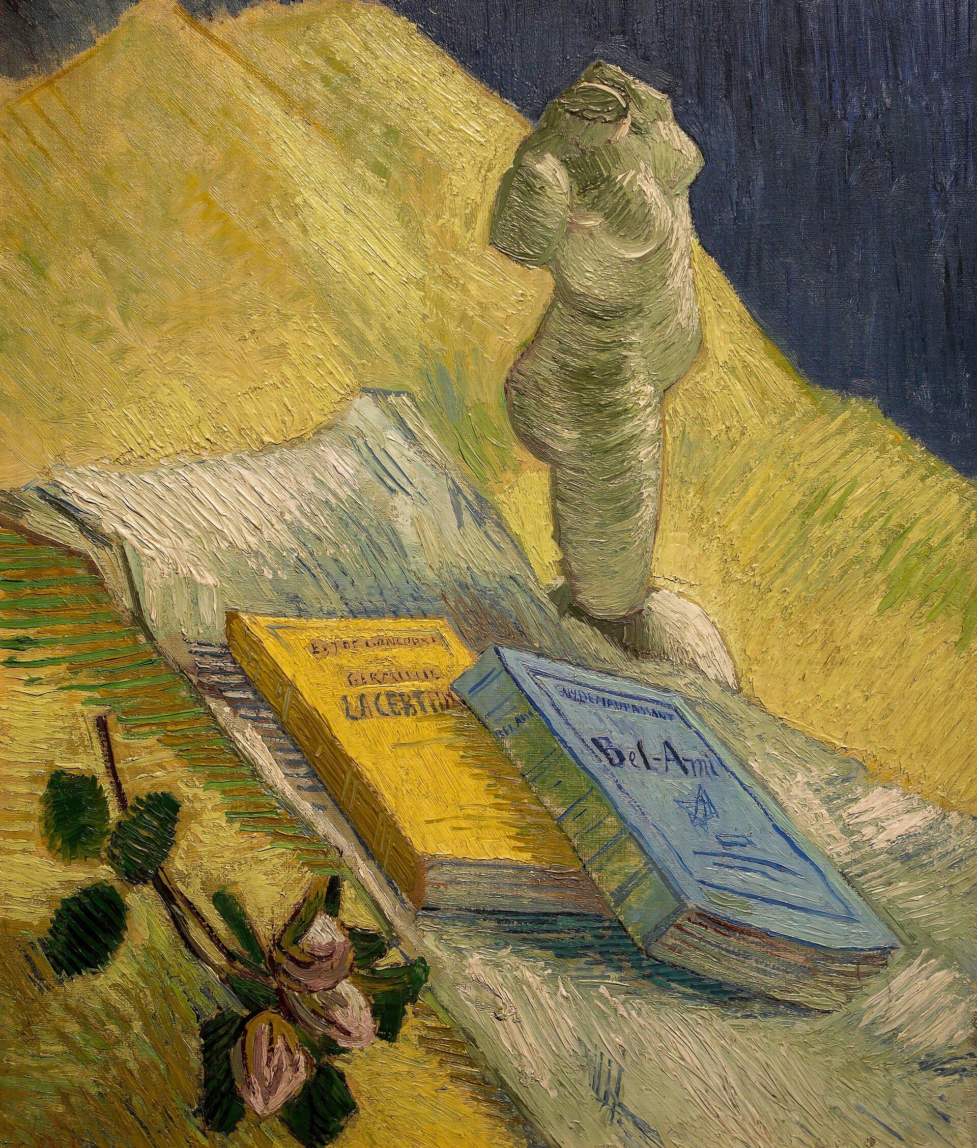 A plaster figure, books and a rose on a studio table