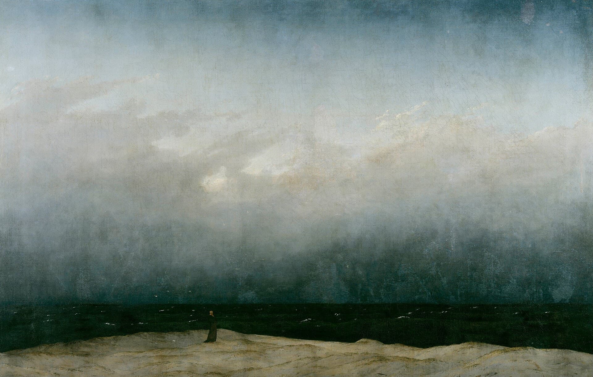 A lone figure on a shore beneath an enormous grey sky